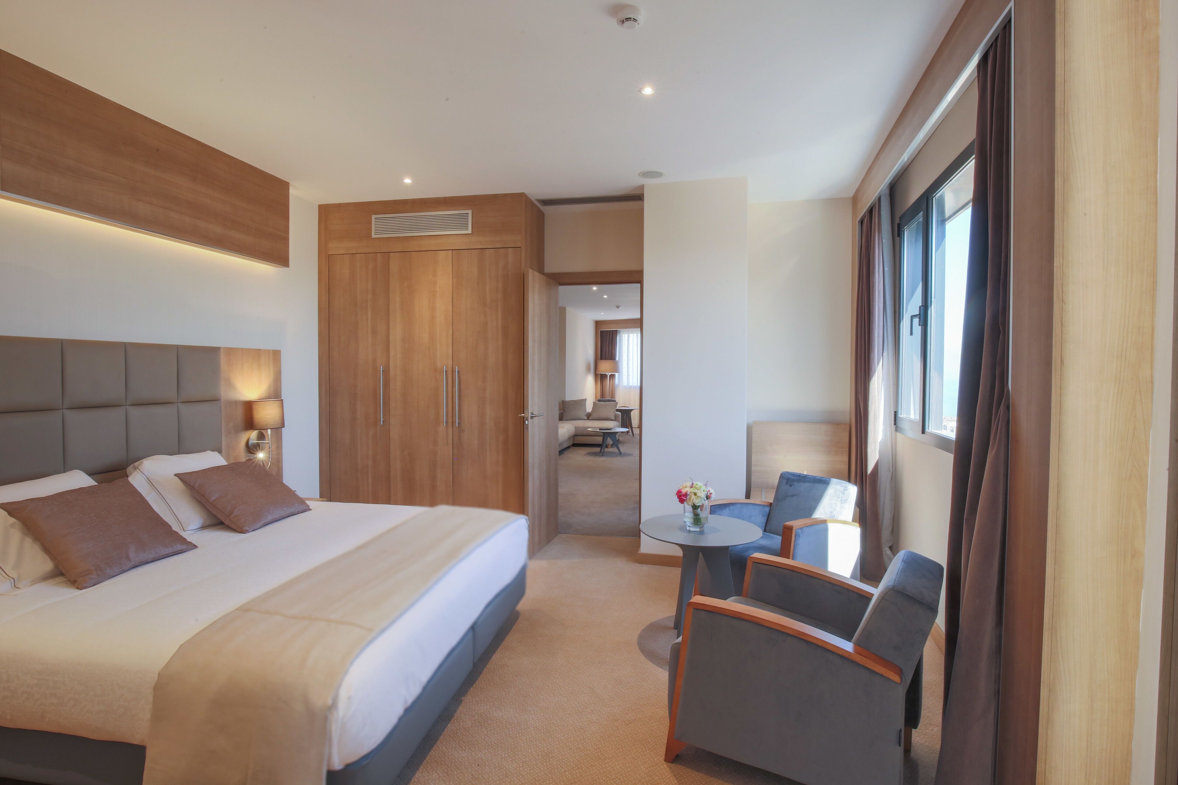 Une chambre d’hôtel moderne dotée d’un grand lit, d’un bureau et d’un coin salon.