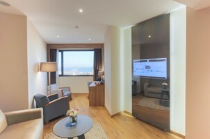 Suite Deluxe, vistas al mar | Zona de estar | Una televisión de pantalla plana