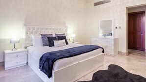 A bedroom with a large bed, white nightstands, a dresser, and a mirror. - Bespoke Residences - North Residence (Dubai)