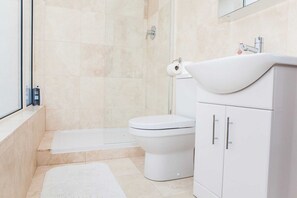 A modern bathroom with a toilet, sink, and shower.
