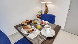 A breakfast setup with a plate of eggs, bacon, toast, and jam on a table with a coffee cup and a lamp. - Le Nautica by Akena Hotels (Perros-Guirec)