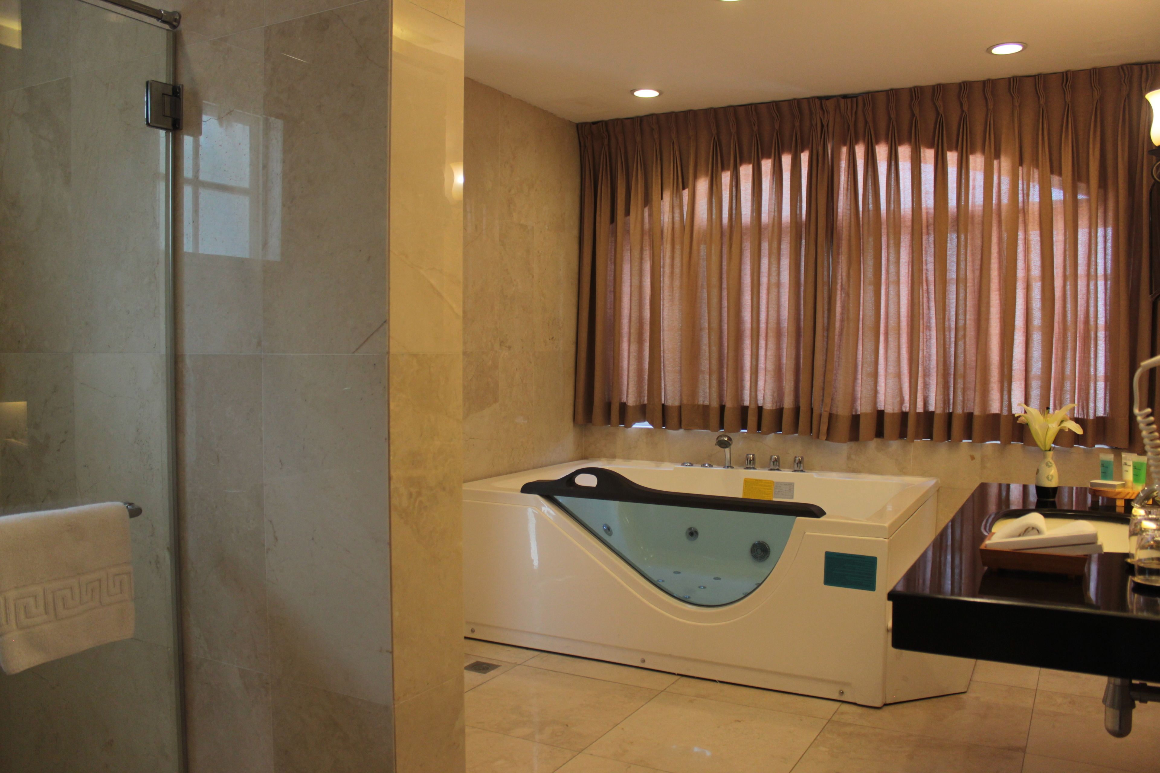 A bathroom with a glass-enclosed shower, a freestanding bathtub, and a vanity with a mirror.