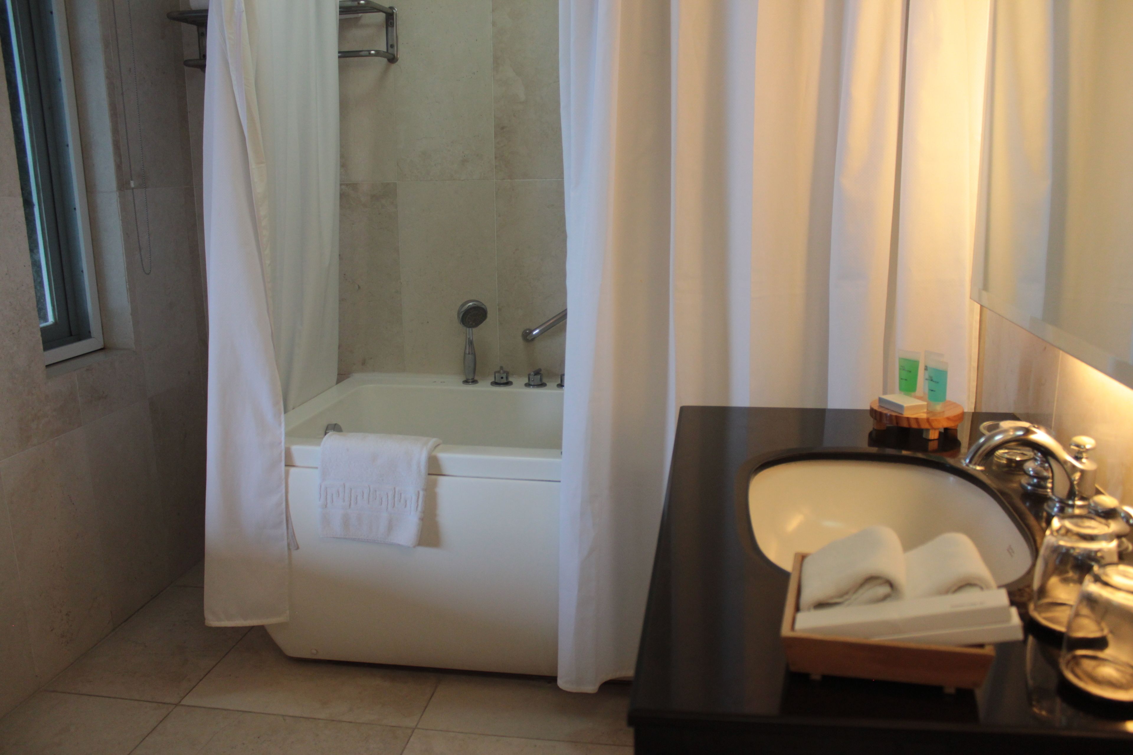 Een badkamer met een bad, een wastafel en een douche.