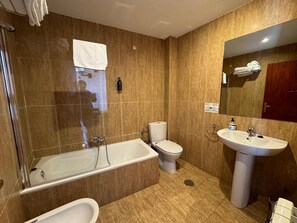 A modern bathroom with a bathtub, a toilet, and a sink. - Hotel La Fuente (Candelario)