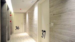 A hallway with wooden flooring and walls, featuring doors numbered 36 and 37. - 41 Twelve (Beirut)
