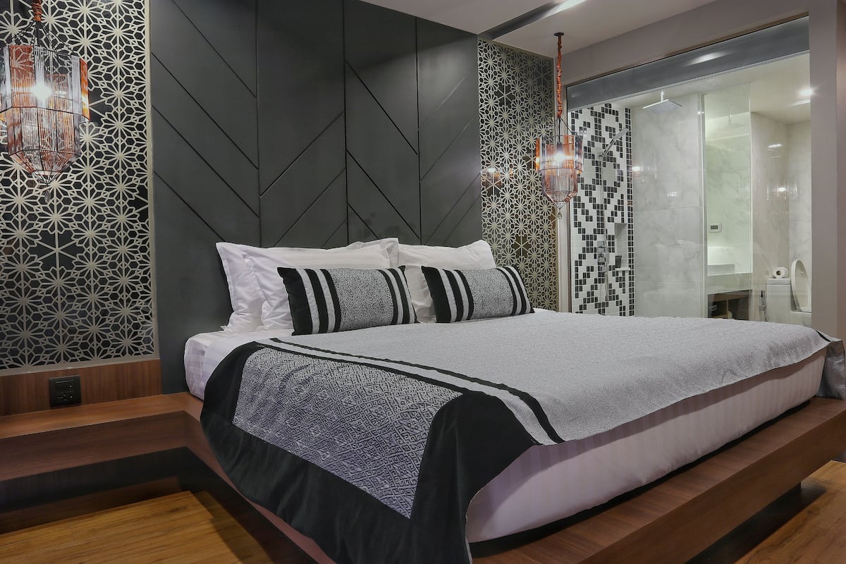A modern bedroom with a bed, a nightstand, and a walk-in closet.