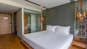 Habitació d'hotel moderna amb un llit gran, un armari encastat i una paret amb un disseny decoratiu.