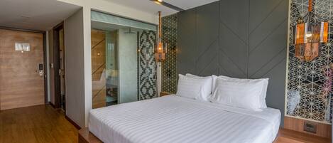 Una habitación de hotel moderna con una cama grande, un vestidor y una pared con diseño.