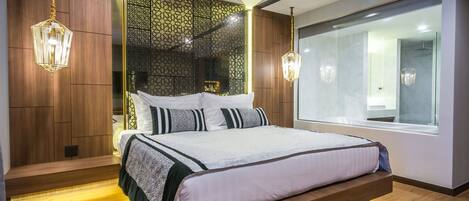 A modern bedroom with a large bed, wooden paneling, a decorative wall, and a large window.