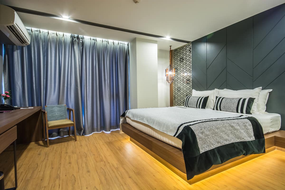 A modern bedroom with a bed, a desk, and a chair.