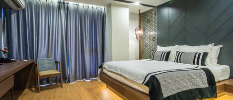 A modern bedroom with a bed, a desk, and a chair.