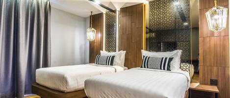 Una habitación de hotel moderna con dos camas, cabeceros de madera y un panel decorativo en la pared.
