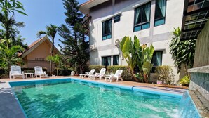 A swimming pool with clear water, surrounded by white lounge chairs and greenery. - Rim Khao Jungle Resort (Ko Lanta)