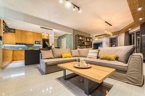 Una sala de estar moderna con un sofá, una mesa de centro y una cocina al fondo.