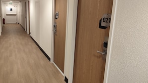 Een hotelgang met houten deuren, elk voorzien van een nummer.