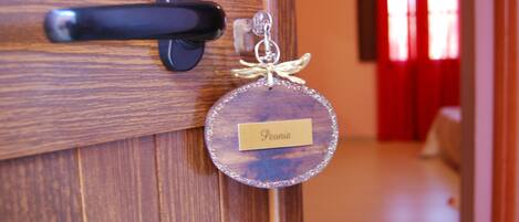 A wooden door with a black handle and a round, glittery keychain with a name tag.