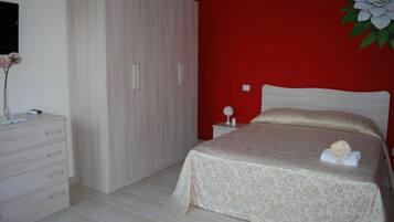 A bedroom with a bed, a dresser, and a wardrobe.