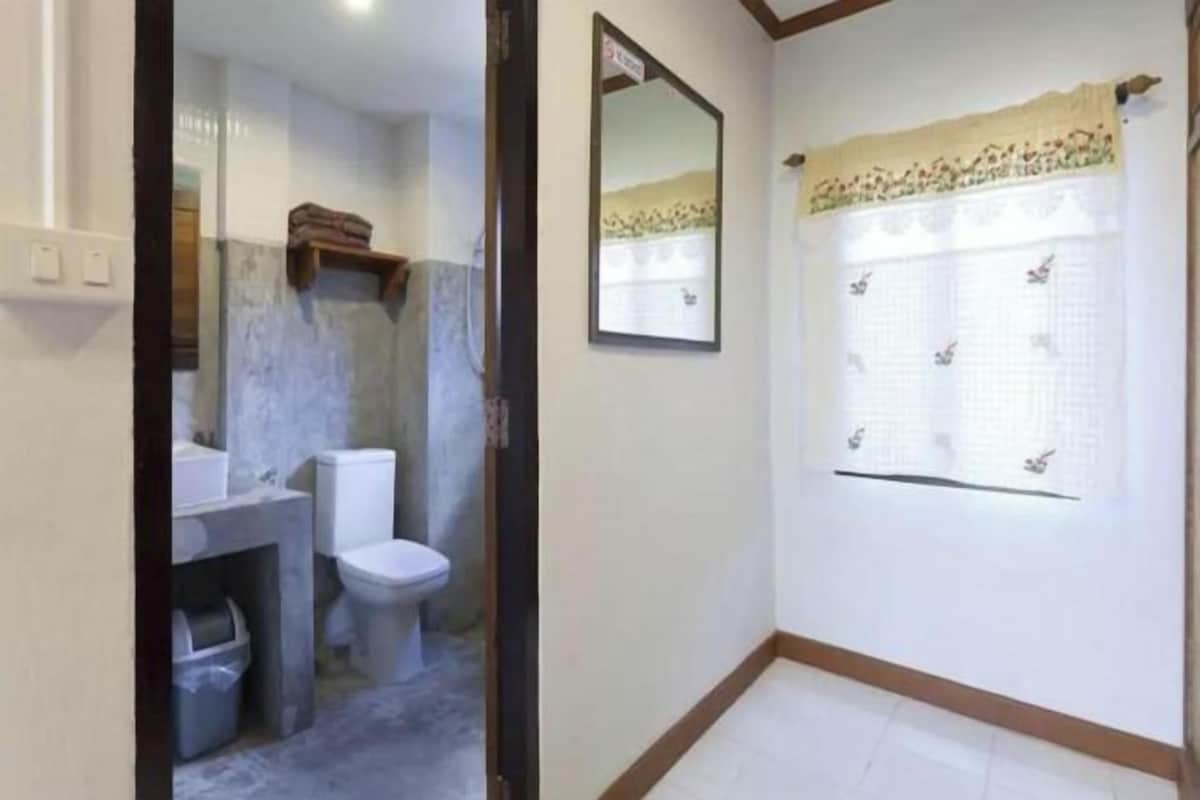 A bathroom with a toilet, sink, and mirror.