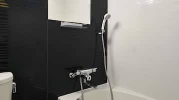 Un baño moderno con bañera, inodoro y espejo.