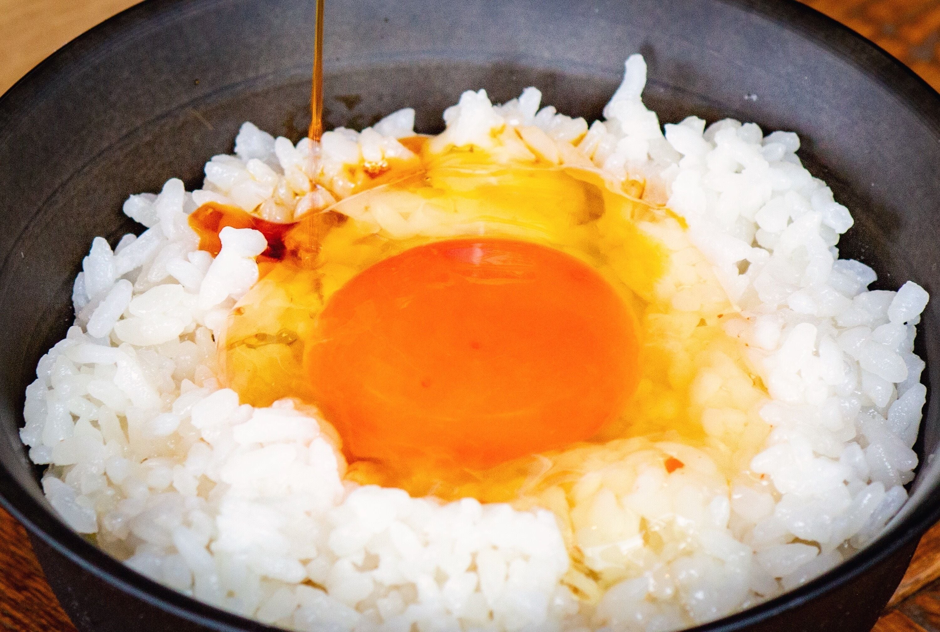 A bowl of white rice with an egg yolk in the center.