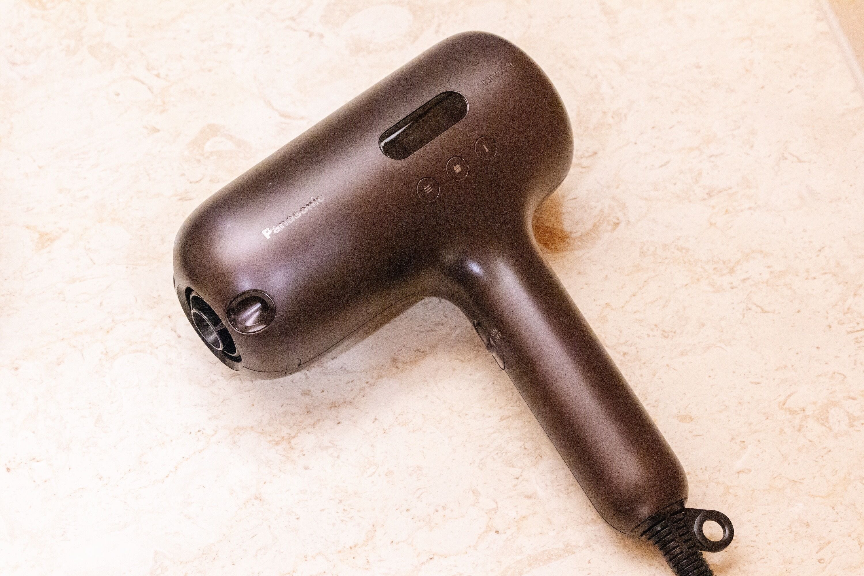 A hair dryer with a cord and a power button.