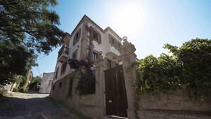 Un edificio de fachada de piedra, con una entrada central y una escalera que conduce a ella.