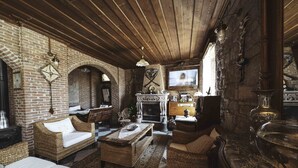 Una habitación acogedora con muebles de mimbre, chimenea y televisión.