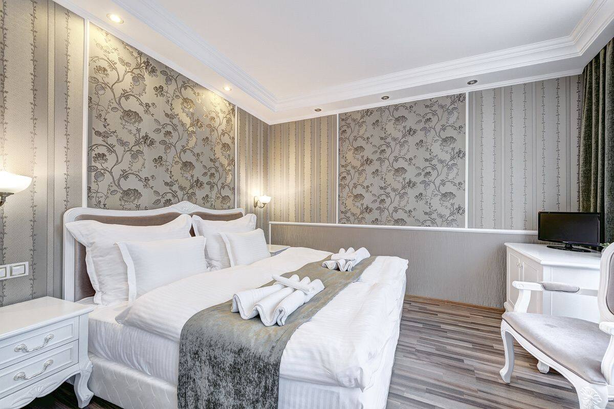 Una habitación de hotel con una cama grande, un escritorio, una silla y un televisor.