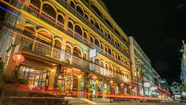 A multi-story hotel with balconies, large windows, and traditional architectural design. - Minatale Phuket (Patong)