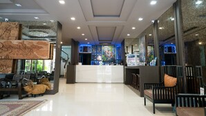 A hotel lobby with a reception desk, seating area, and decorative elements. - Minatale Phuket (Patong)