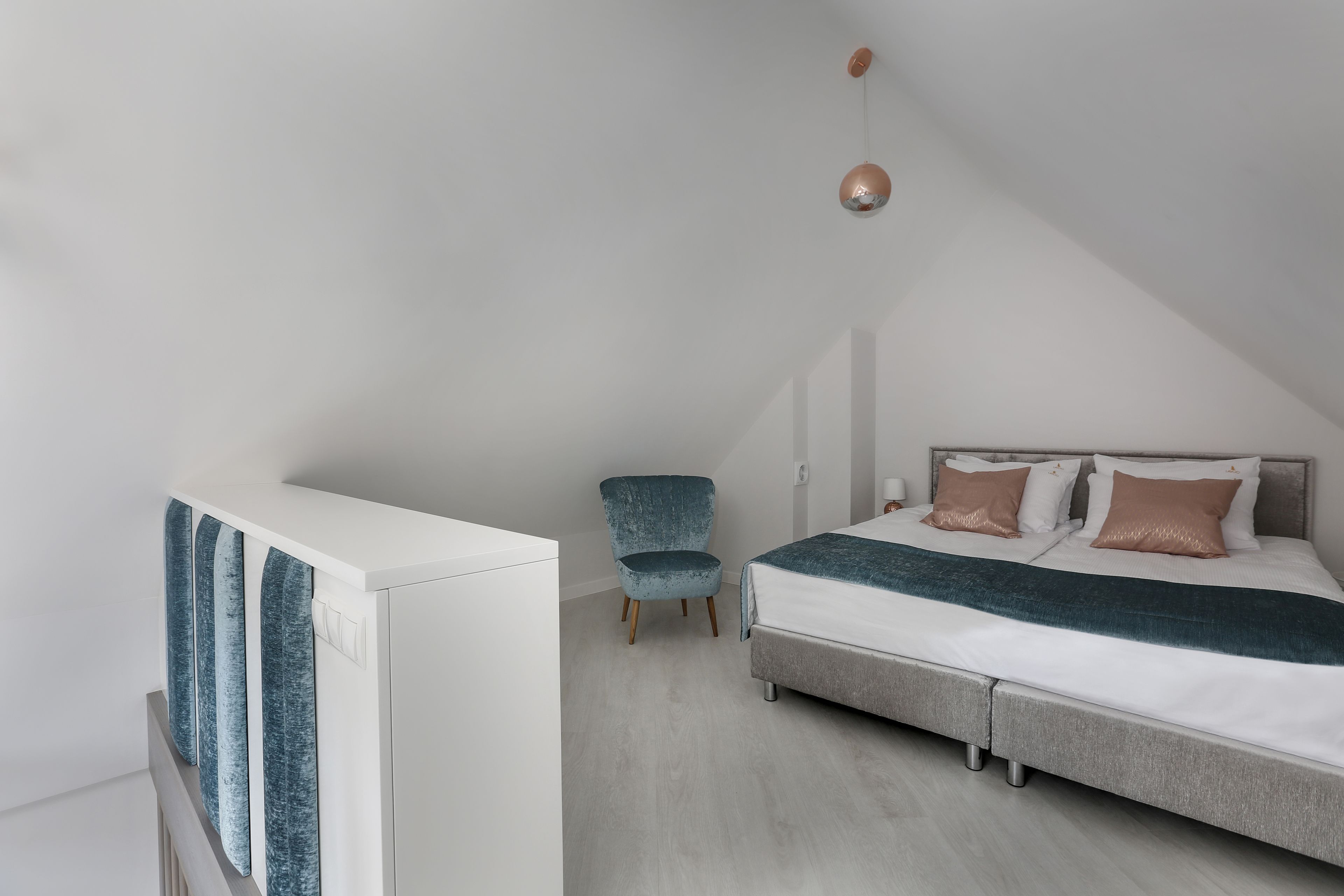 Une chambre à coucher avec un lit, une chaise et une armoire.