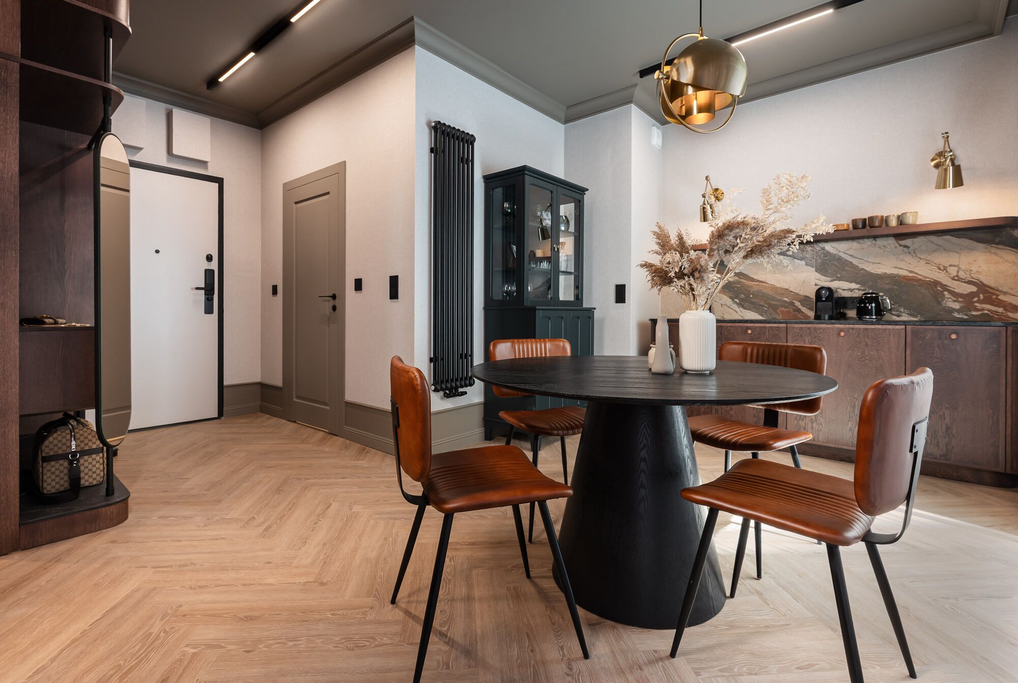 A modern dining area with a round table, six chairs, and a decorative vase.