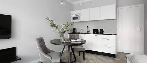 Una sala de estar moderna y minimalista con comedor, cocina y televisor.