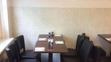 A conference room with a table, chairs, and a clock on the wall.