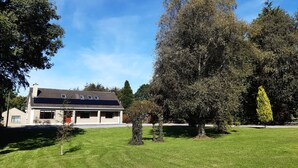 A house with a sloped roof, a front porch, and a well-maintained lawn.