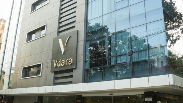A modern building with a glass facade and the sign 'Vdara'. - Vybrant Hotels (Vijayawada)