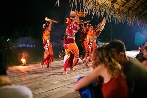 A traditional dance performance on a wooden stage with a thatched roof overhead. - Amuna Ayurveda and Wellness Retreat (Sigiriya)