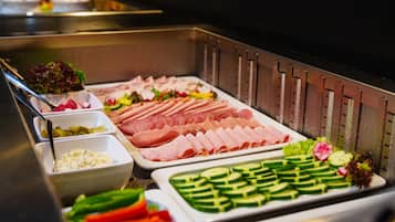 A buffet with various food options including meats, vegetables, and salads.