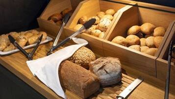 A display of various breads and pastries in wooden boxes.