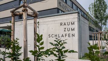 Un edificio con un letrero que dice "RAUM ZUM SCHLAFEN", indicando una zona para dormir.