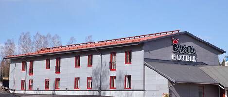 A building with a sign reading "Rastia Hotel" and a red roof.