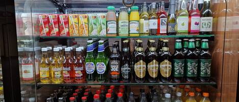 A refrigerated display case with various beverages including sodas, juices, and alcoholic drinks.