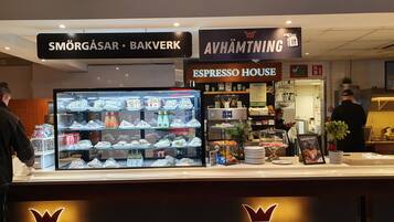 Un comptoir de boulangerie où sont exposés des produits de boulangerie et où se trouve une machine à café.