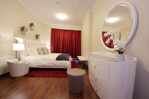 A bedroom with a bed, bedside table, dresser, and a mirror. - Piks Key - Marina Torch Tower (Dubai)