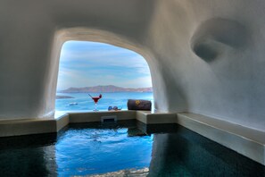 Une piscine à débordement offrant une vue dégagée sur la mer et le paysage lointain.