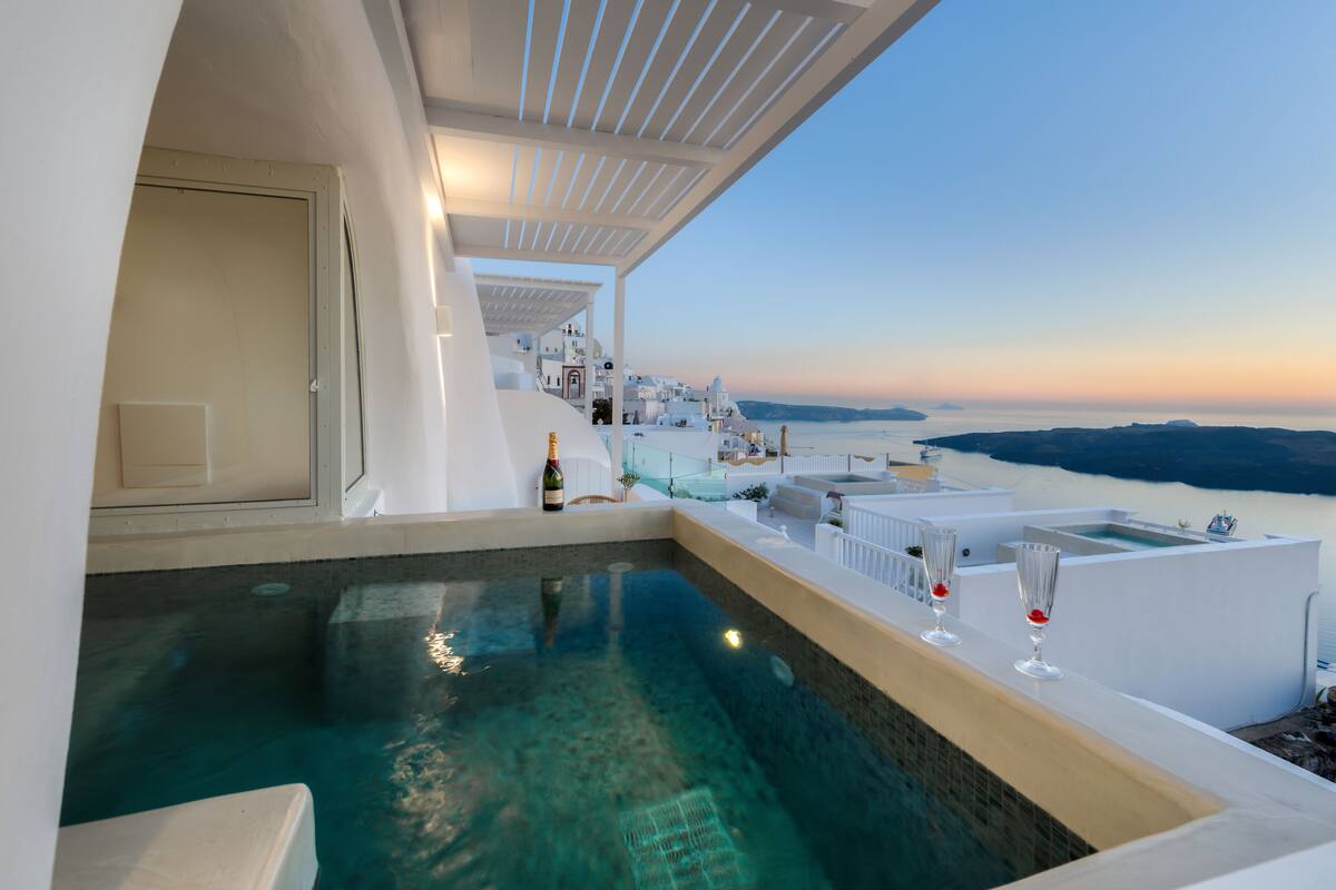 Una piscina infinita con vistas despejadas al mar y un atardecer.