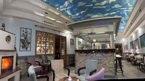 Een restaurant met een plafonddecoratie van wolken, een open haard en een bar.