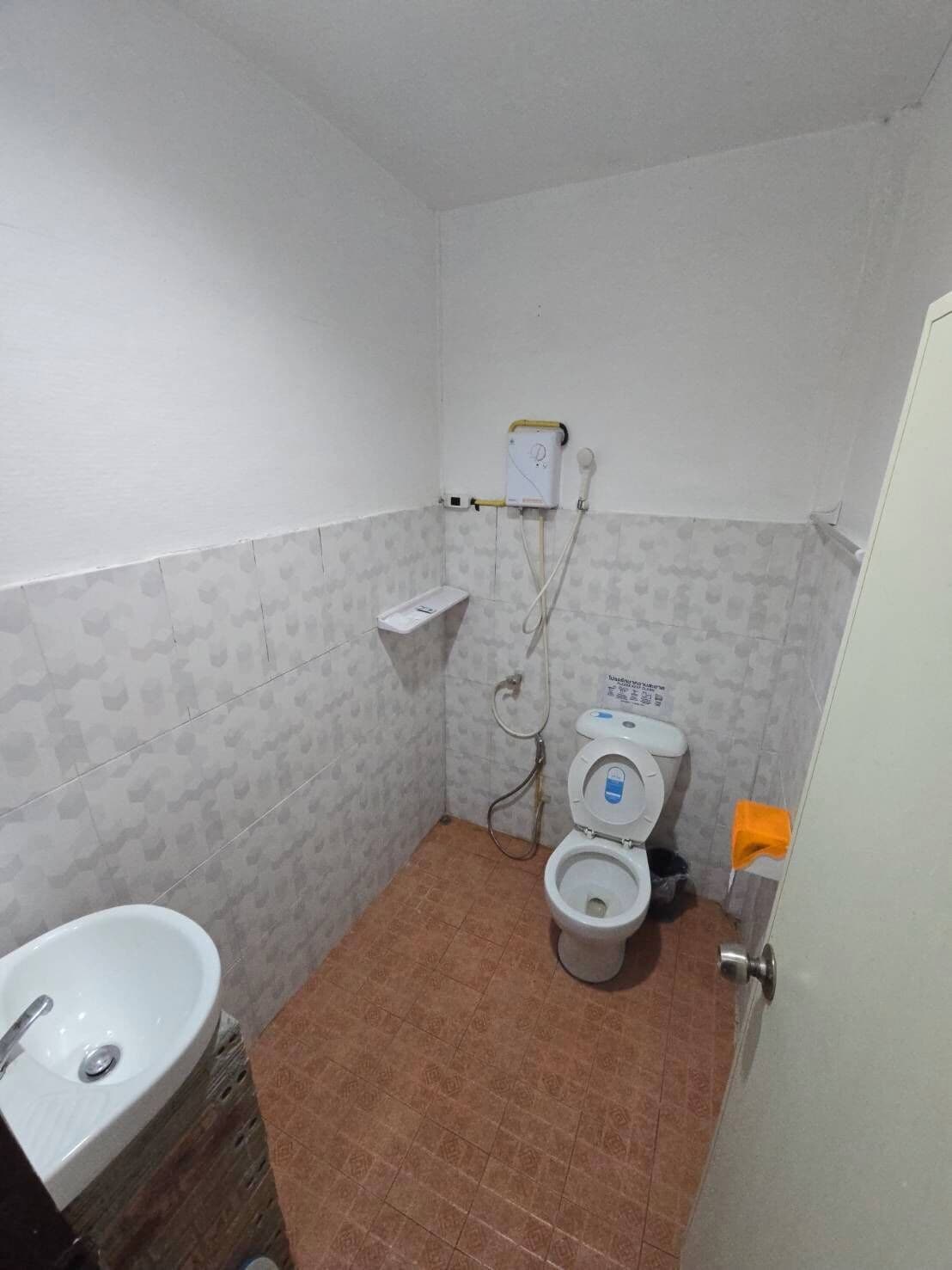 Un baño pequeño con inodoro, lavamanos y ducha.
