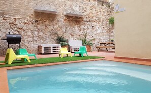 Una piscina al aire libre, tumbonas