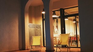 An indoor swimming pool with two chairs and a table in the background. - Ten To Go Hostel (Barcelona)